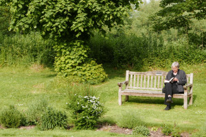 教会の庭で読書する婦人